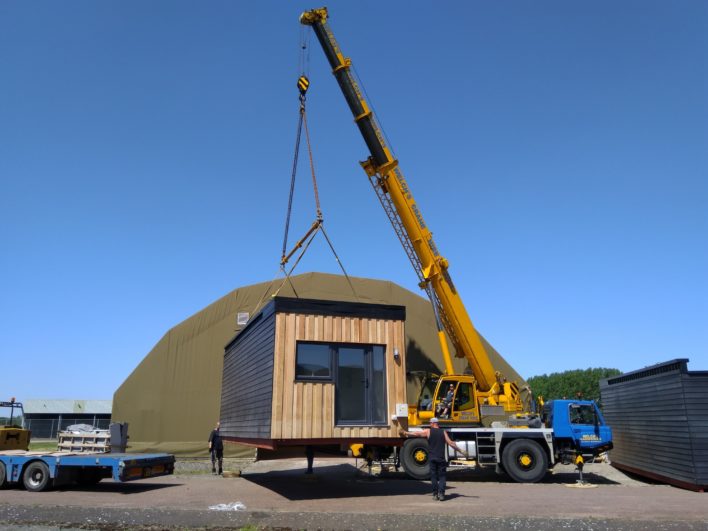 New Meaning Foundation staff using crane to load modular home onto low loader