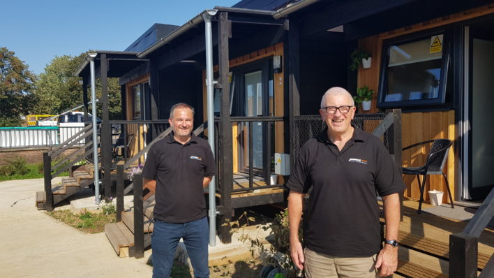 John and Nick from New Meaning Foundation outside some modular homes that were built for another site