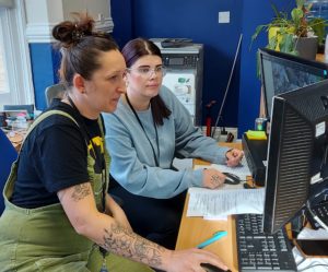 A Wintercomfort worker helps a service user on a computer