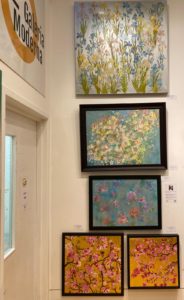 Photo showing some of Sarah's paintings hanging on a wall at Galeria Moderna